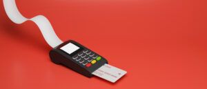 Payment terminal with credit card and receipt isolated on red background, 3D render